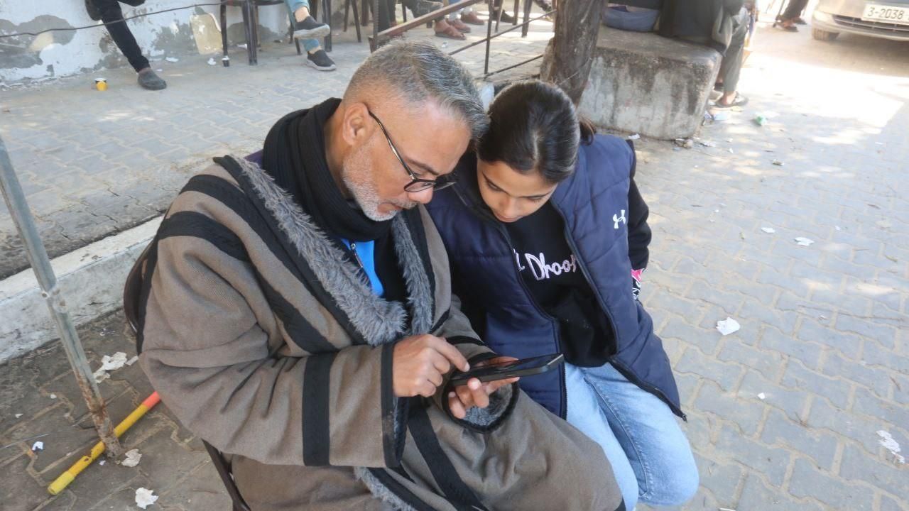 Sevdikleriyle konuşmak isteyen Gazzeliler internet kafenin önünde toplanıyor