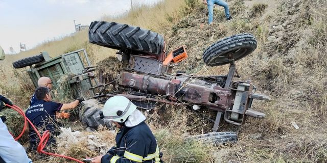 Devrilen traktörün altında kalan sürücüyü itfaiye ekipleri kurtardı