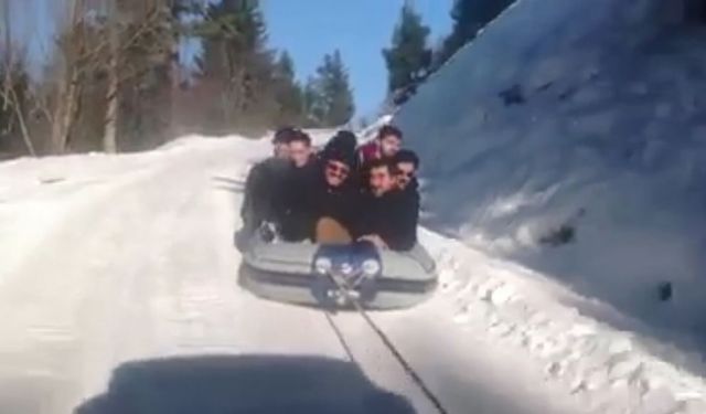 Araçlarına bağladıkları rafting botuyla kar üstünde kayarak çocuklar gibi eğlendiler