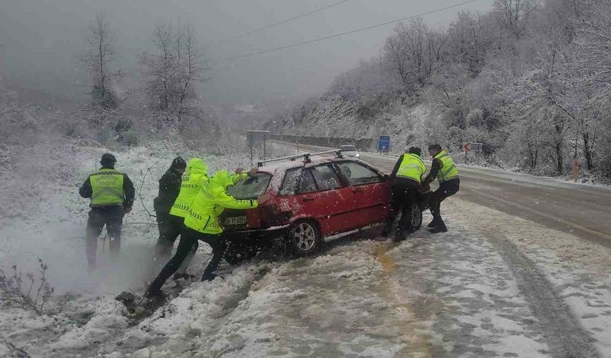 Kar yağışı sebebiyle şarampole kayan aracı, jandarma ve polis ekipleri iterek kurtardı